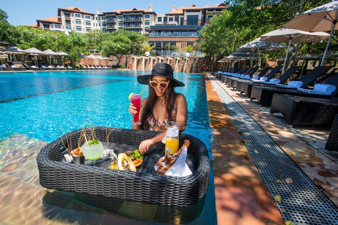 The Capital Zimbali Otel Ballito Dış mekan fotoğraf A woman at a poolside lounge